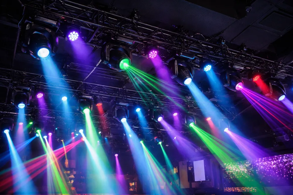 إضاءات DJ احترافية للنوادي مثبتة في مصفوفة سقفية بنادٍ ليلي مع حزم ضوئية يتم التحكم بها عبر DMX