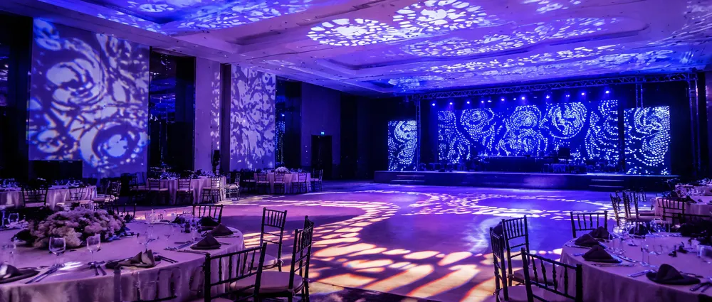 Gobo patterns projected across a venue interior — branded imagery on walls and ceiling from Vefey fixtures